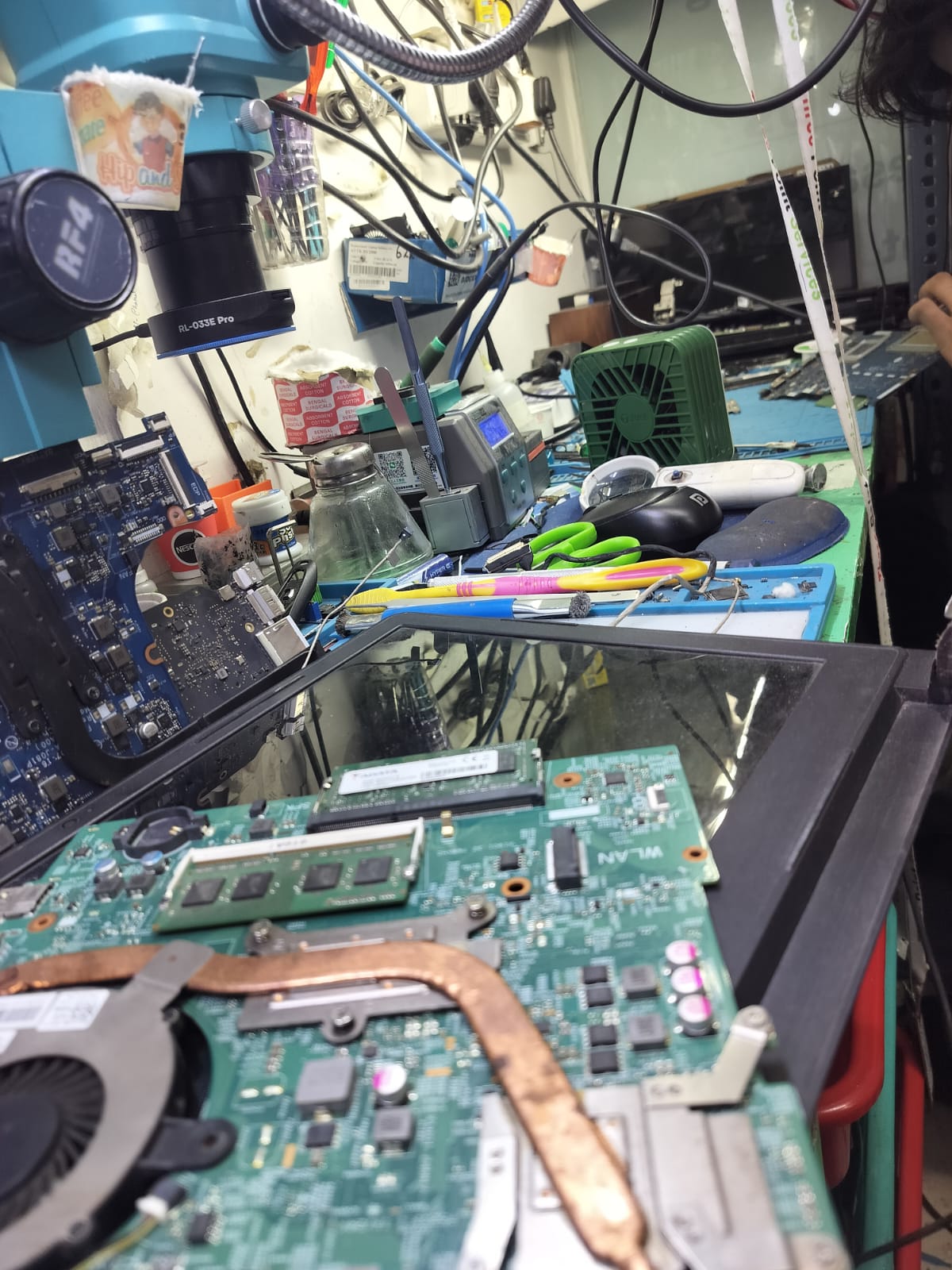 Repair workstation with motherboard components and tools prepared for chip-level work