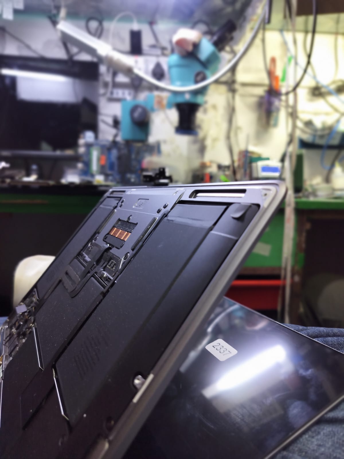 Opened MacBook photographed at an angle inside the repair workshop