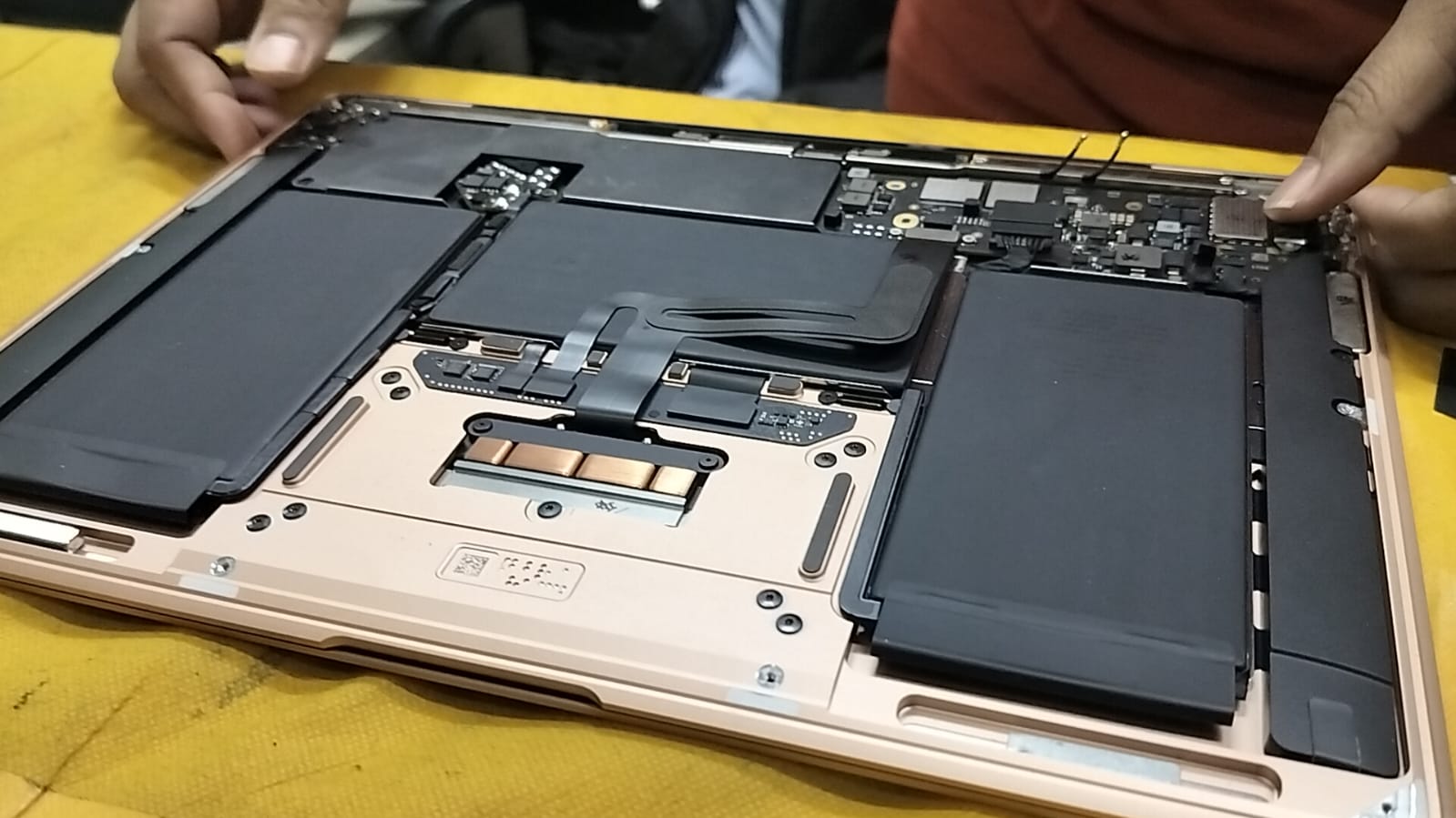 Opened MacBook showing internal battery and board layout during repair